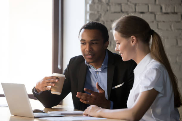 istock Diverse employees negotiate near laptop discussing ideas 1129819901