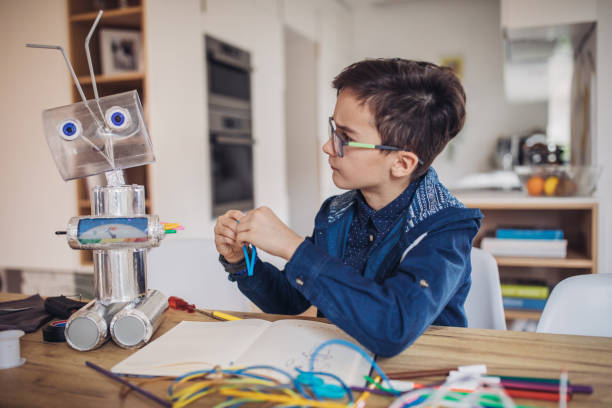 istock Boy making robot of recycling material for school project 1129819921