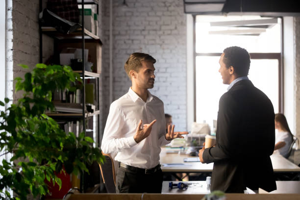 istock Colleagues standing having casual conversation in office 1129819949