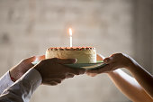 Close up of employee presenting cream pie with candle