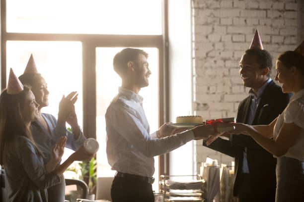 istock Excited employees congratulating smiling coworker with birthday 1129819953