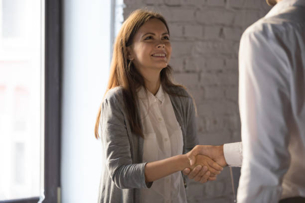 istock Businessman handshake excited female worker greeting with success 1129819957