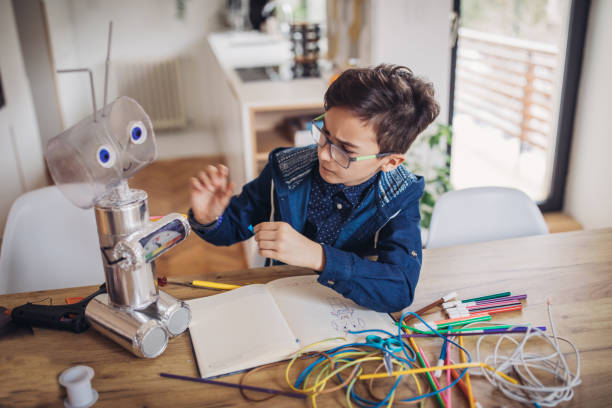 istock Boy making robot of recycling material 1129820305