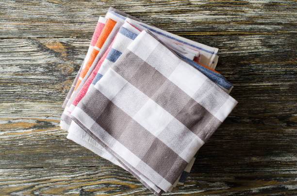 Stack of kitchen towels or napkins over the rustic wooden table. Stack of kitchen towels or napkins over the rustic wooden table. View from above with copy space life stile stock pictures, royalty-free photos & images