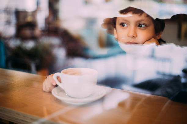 Little boy drinking hot chocolate at coffee shop