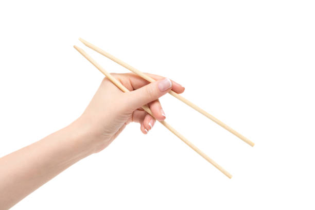 istock Female hand holds chopsticks on a white background. 1129823149