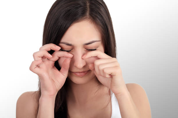istock pretty girl with a strong headache on a grey backgroun 1129823230