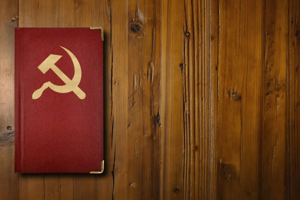 libro comunista sobre tablero de madera - hoz y martillo fotografías e imágenes de stock