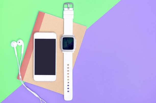 istock Empty mobile phone with smartwatch gadgets on green purple copy space 1129827201