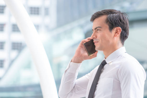 istock Young Business man Man using telephone in modern city 1129827431