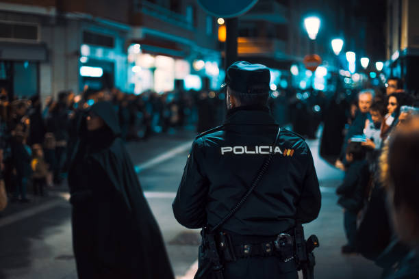 Rear view of Police officer watching during crowded religious event. Holy Week in Zamora, Spain (easter week). Zamora, Spain - March 31, 2018:. Rear view of Police officer watching during crowded religious event. Holy Week in Zamora, Spain (easter week). Holy Week is celebrated by 16 Catholic religious brotherhoods and fraternities that perform penance processions on the streets of the city. blue brothers stock pictures, royalty-free photos & images