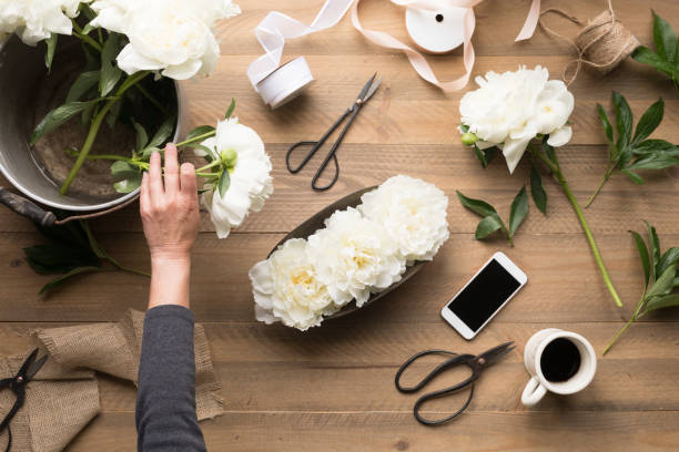istock Woman's Hand arranging flowers in floral arrangements 1129829349