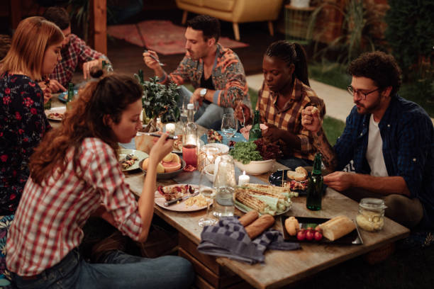 istock Multi-ethnic friends enjoying dinner party at yard 1129829678