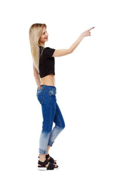 istock Side view of a girl walking with a pointing hand. 1129832811