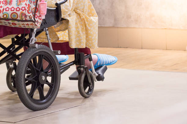 пожилые люди носят тапочки на инвалидной коляске с теплым светом в больнице - slipper senior adult shoe human leg стоковые фото и изображения