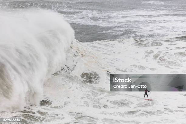 Surfing In Giant Waves Of Nazare Portugal Stock Photo - Download Image Now - Surfing, Wave - Water, Nazare