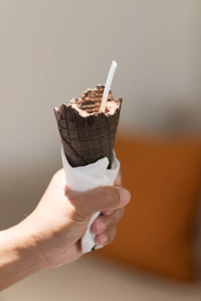 istock Ice cream cone chocolate in hand, close up 1129839712