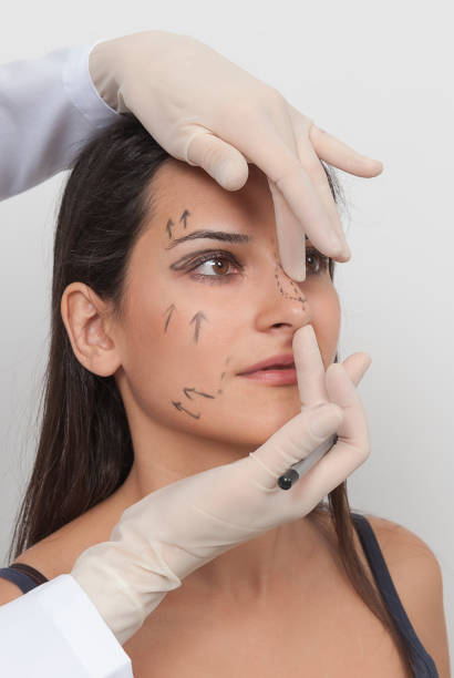 chirurgo estetico che esamina la cliente donna. dottore che controlla il viso, il naso e il naso della donna prima dell'intervento di chirurgia plastica. mani chirurghe o estetista che toccano il viso della donna. rinoplastica - nose job foto e immagini stock