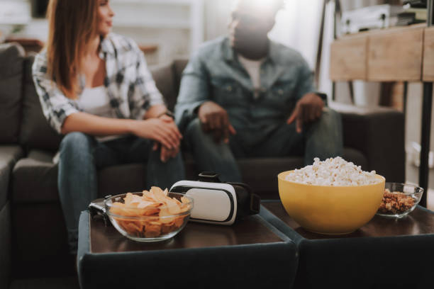istock Young friends spending time at home with snacks and VR headset 1129840269