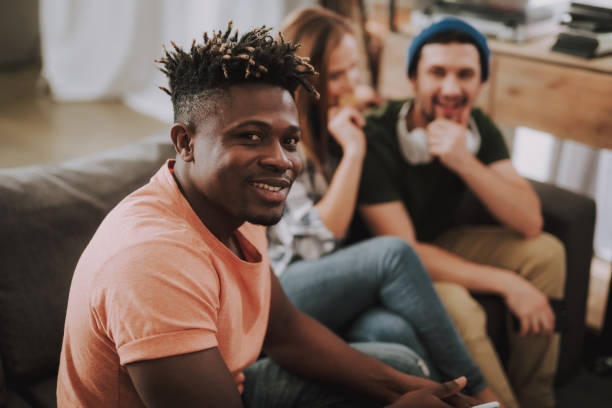 istock Joyful afro american guy spending time with friends at home 1129840315