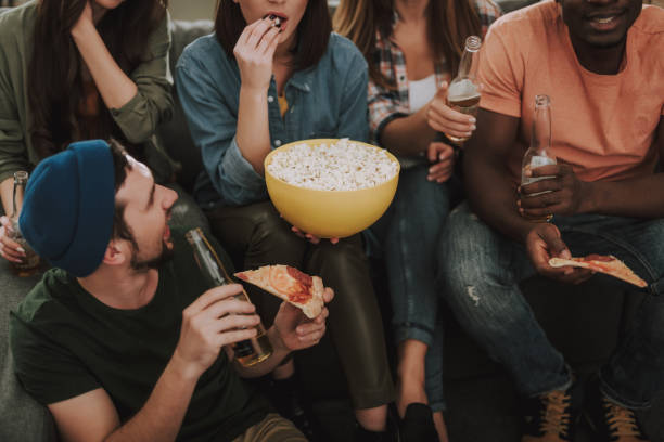 istock Young people eating and drinking while spending time together at home 1129840347