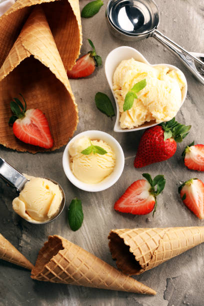 istock Vanilla ice cream scoop with fresh strawberries and icecream cones 1129841277