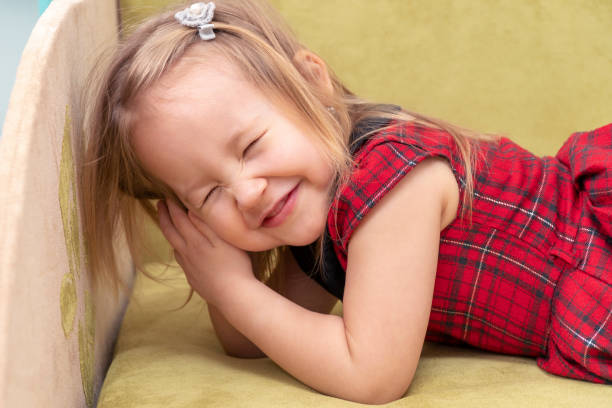 little beautiful girl lying on the bed shut her eyes and smiling
