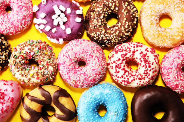 istock assorted donuts with chocolate frosted, pink glazed and sprinkles donuts 1129841832
