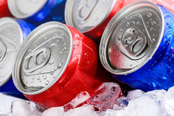Red and blue soda cans on ice with condensation droplets Soda Cans on crushed ice. Red and blue cans with droplets close-up macro cooler container photos stock pictures, royalty-free photos & images