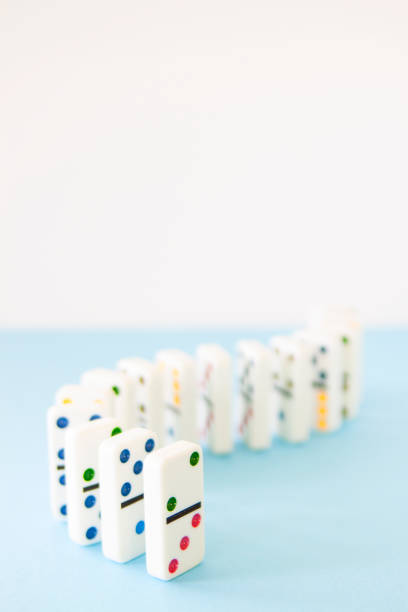 istock White dominos with brightly colored dots lined up in a curving series 1129841993