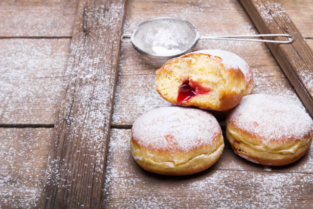 istock Traditional Polish donuts on wooden background. Tasty doughnuts with jam. 1129843396