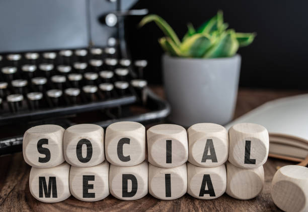 words social media on wooden blocks against vintage typewriter and potted plant on desk - typewriter retro revival old fashioned the media imagens e fotografias de stock