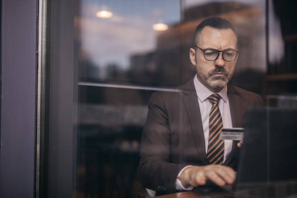 istock Senior man with laptop and credit card 1129846103