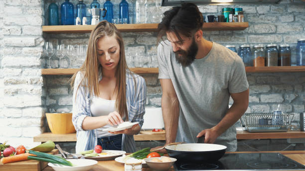 istock Young couple making dinner together at home 1129847334