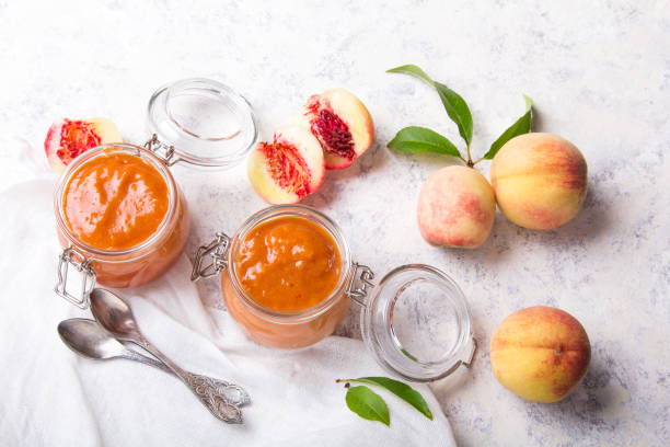 homemade peach jam with organic fruit. sweet preserves on a light background, copy space - preserves jar apricot marmalade imagens e fotografias de stock