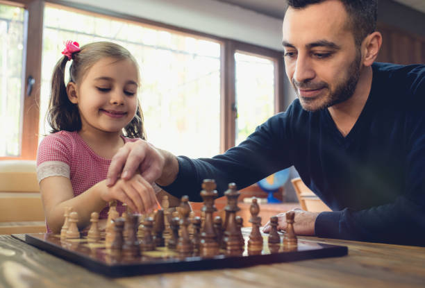 istock Father Teaching His Daughter to Play Chess At Home 1129848649