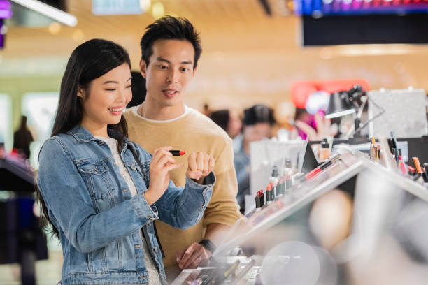 chinese couple trying cosmetics in mall - harbour city imagens e fotografias de stock