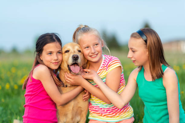 istock Little girls playing with their dog 1129856221