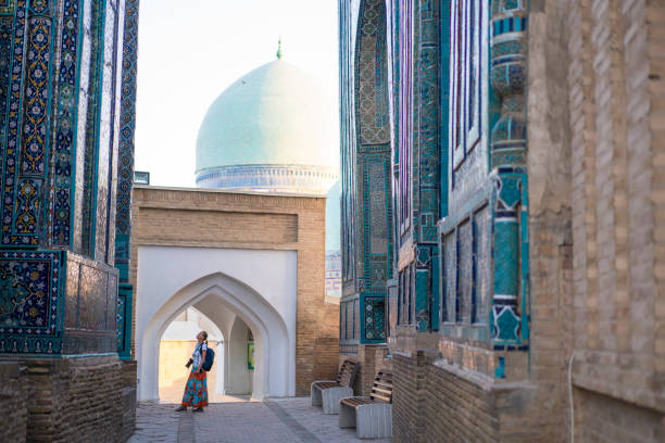 Senior woman at memorial buildings of Shah-I-Zinda Mausoleums in Samarkand, Uzbekistan stock photo