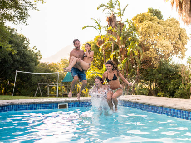 istock Excited friends diving into swimming pool together 1129860919