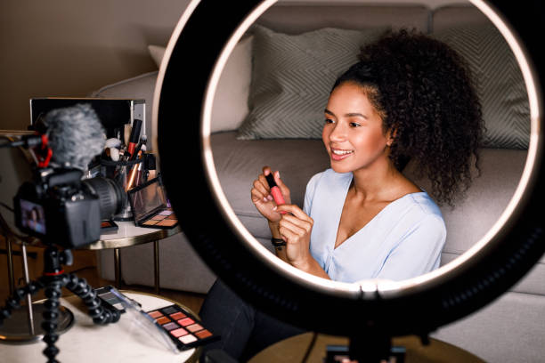 istock Smiling beauty vlogger recording video for her channel using ring light and digital camera 1129866755