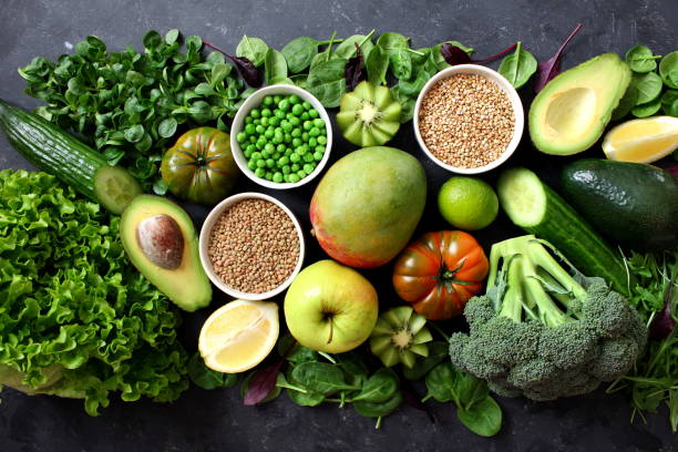 istock Clean eating selection Protein source for vegetarian: avocado, apple, broccoli, spinach, green peas on dark background. 1129868106