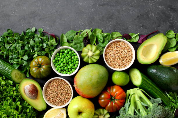 istock Clean eating selection Protein source for vegetarian: avocado, apple, broccoli, spinach, green peas on dark background. 1129868243