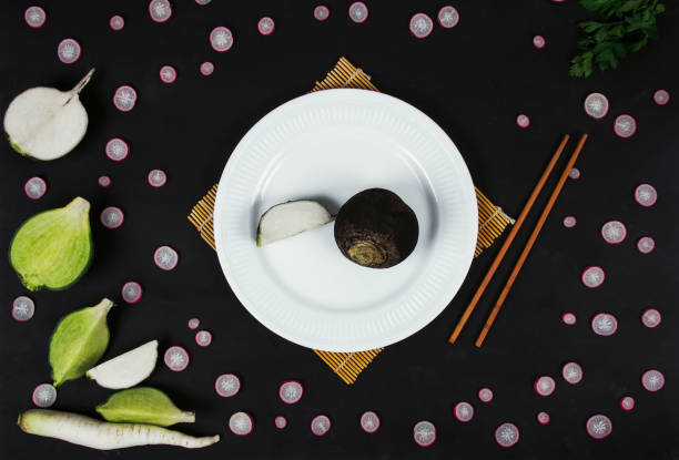 black radish on a plate, on a black background