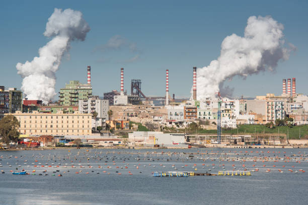 White smoke going up from the chimney of steel plant of  Taranto, Puglia. Italy stock photo