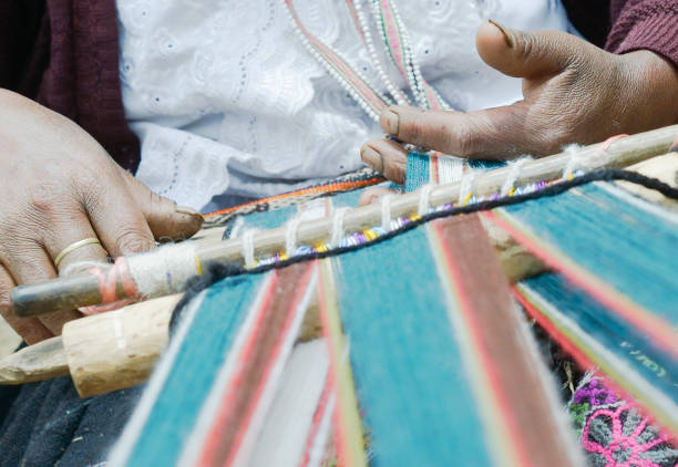 istock Peruvian woman weaving cloth on a hand loom 1129873107