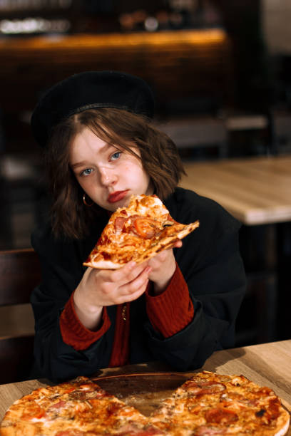 istock Girl in black hat sitting in cafe, posing 1129873259
