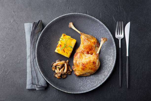 istock Duck legs confit with potato gratin and mushroom sauce. Restaurant serving. Copy space. Top view. 1129894721