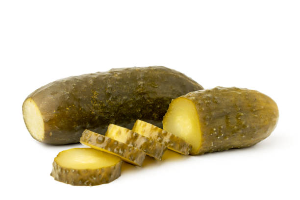 concombre mariné en tranches sur un fond blanc. - cucumber vegetable close up fruit photos et images de collection