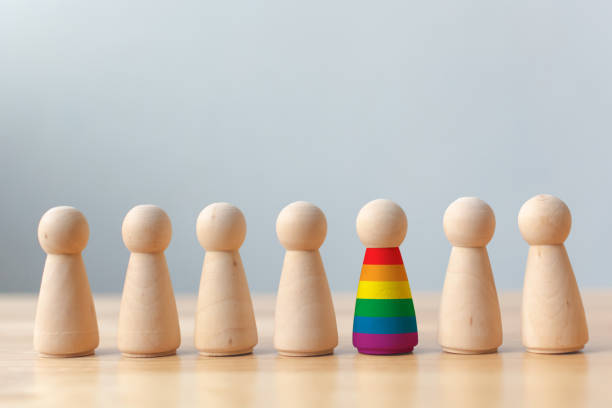 concepto de campaña lgbt de derechos. muñecos de madera con colores del arco iris son diferentes se destacan de la multitud - lesbian gay man rainbow multi colored fotografías e imágenes de stock